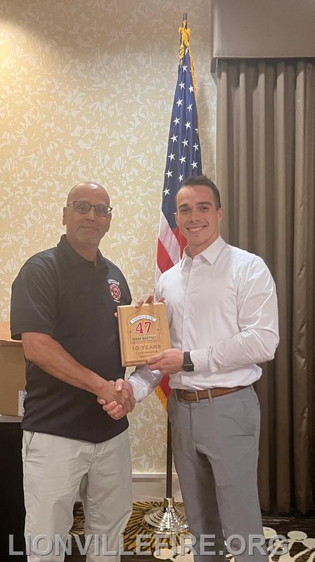 Membership Secretary Jack Jacobson presenting Mark Martinez's Years of Service Award to his father, Firefighter Carlos Martinez