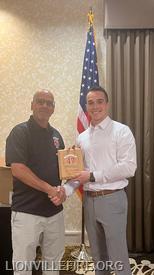 Membership Secretary Jack Jacobson presenting Mark Martinez's Years of Service Award to his father, Firefighter Carlos Martinez